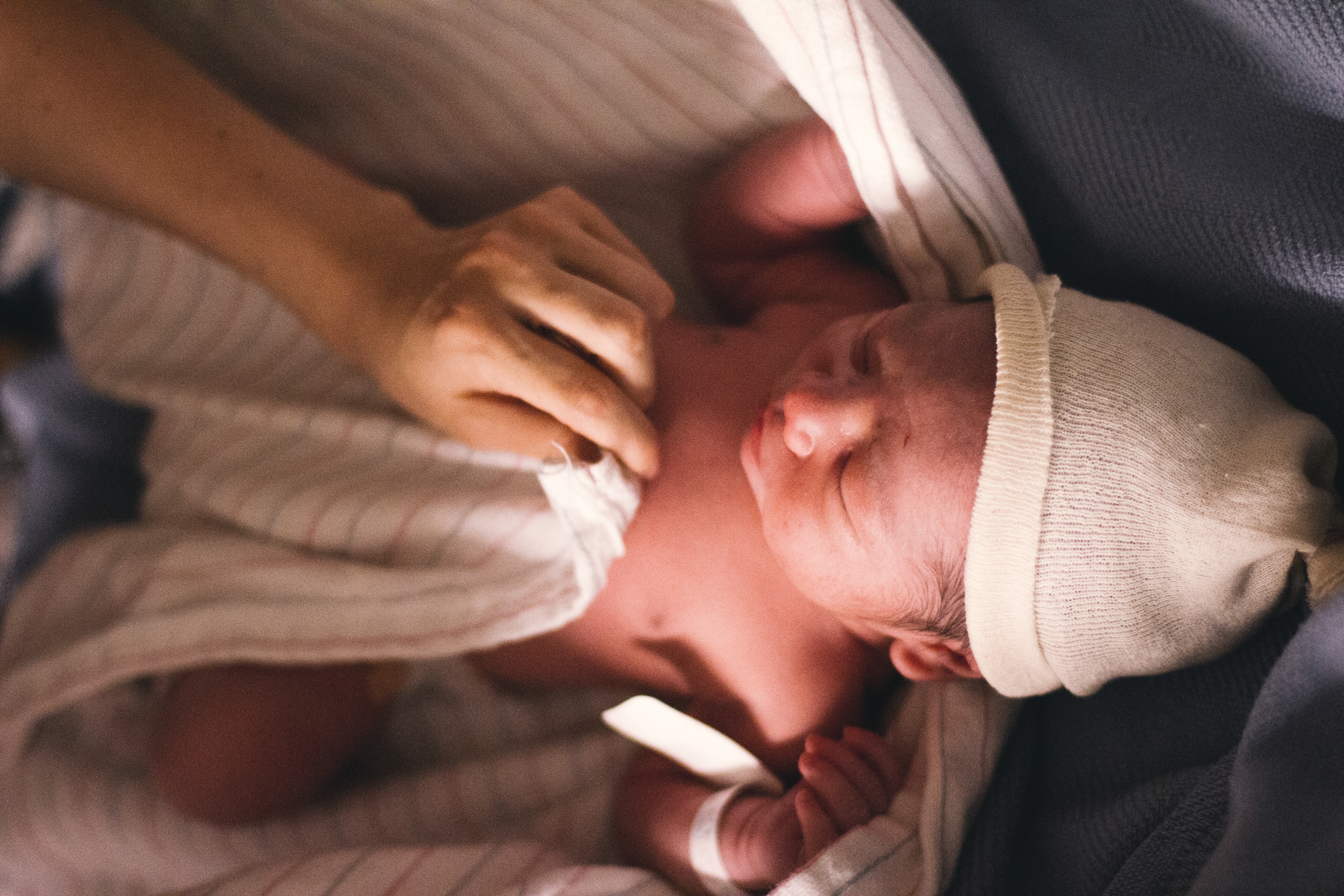 Newborn being swaddled by his experience Newborn care Specialist